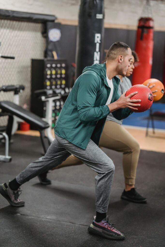 Two athletes performing functional training with medicine balls